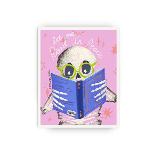 A square art print featuring a cartoon skeleton reading a blue book on a pink background with the words 'let me Read In Peace.' The print is shown centered against a light gray studio background.