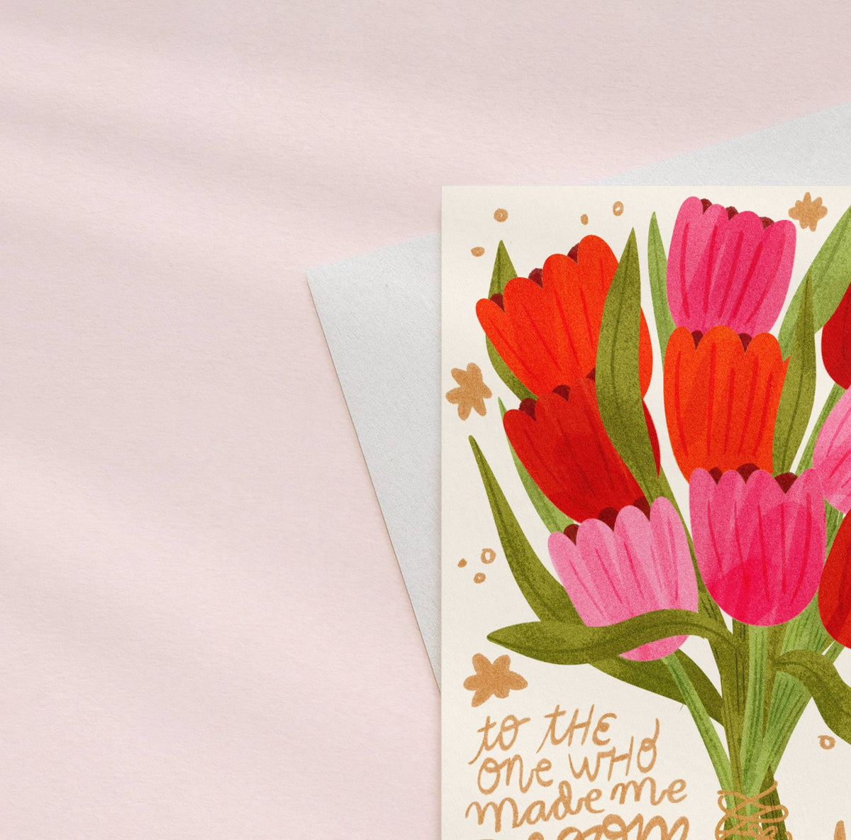 Greeting card with red and pink tulips on a light pink background