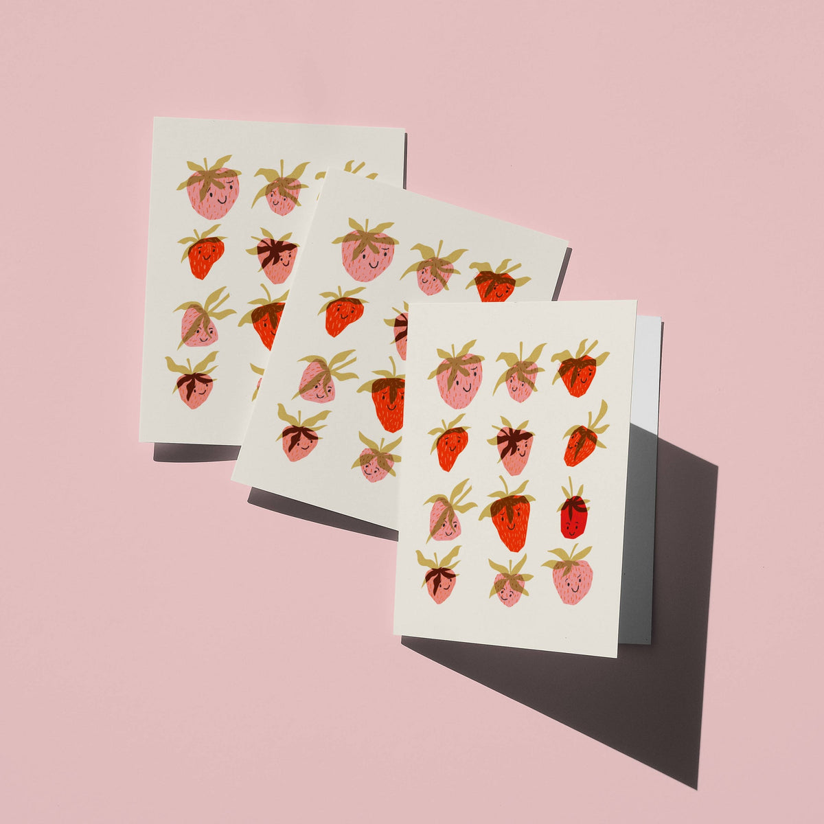 Three greeting cards with strawberry pattern on a pink background