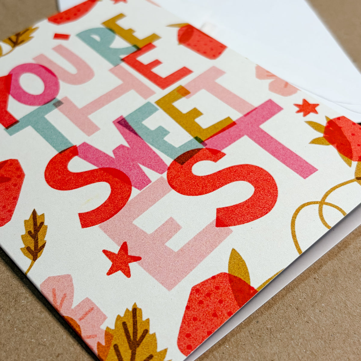 Colorful card with 'You're the sweetest' text on a brown surface
