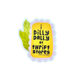 Sticker with text 'i dilly dally at thrift stores' on a wooden surface
