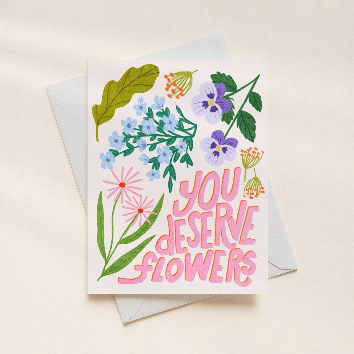 Greeting card with floral design and 'You Deserve Flowers' text on a beige background